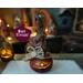 A hand carved pumpkin gourd. She is a cute little witch named Vivian. She has a custom witch hat and is lit with a battery-operated candle.